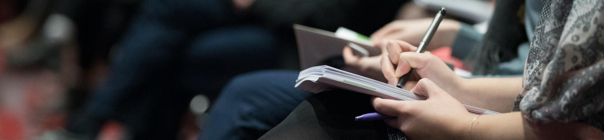 Close-up of people's legs and their notebooks in a class by the climate reality project